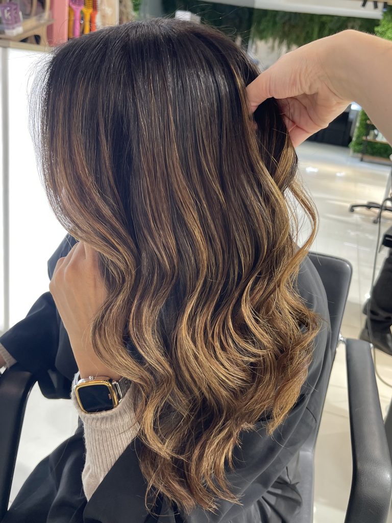 Morena iluminada con reflejos dorados — Identity Peluqueros Valencia
