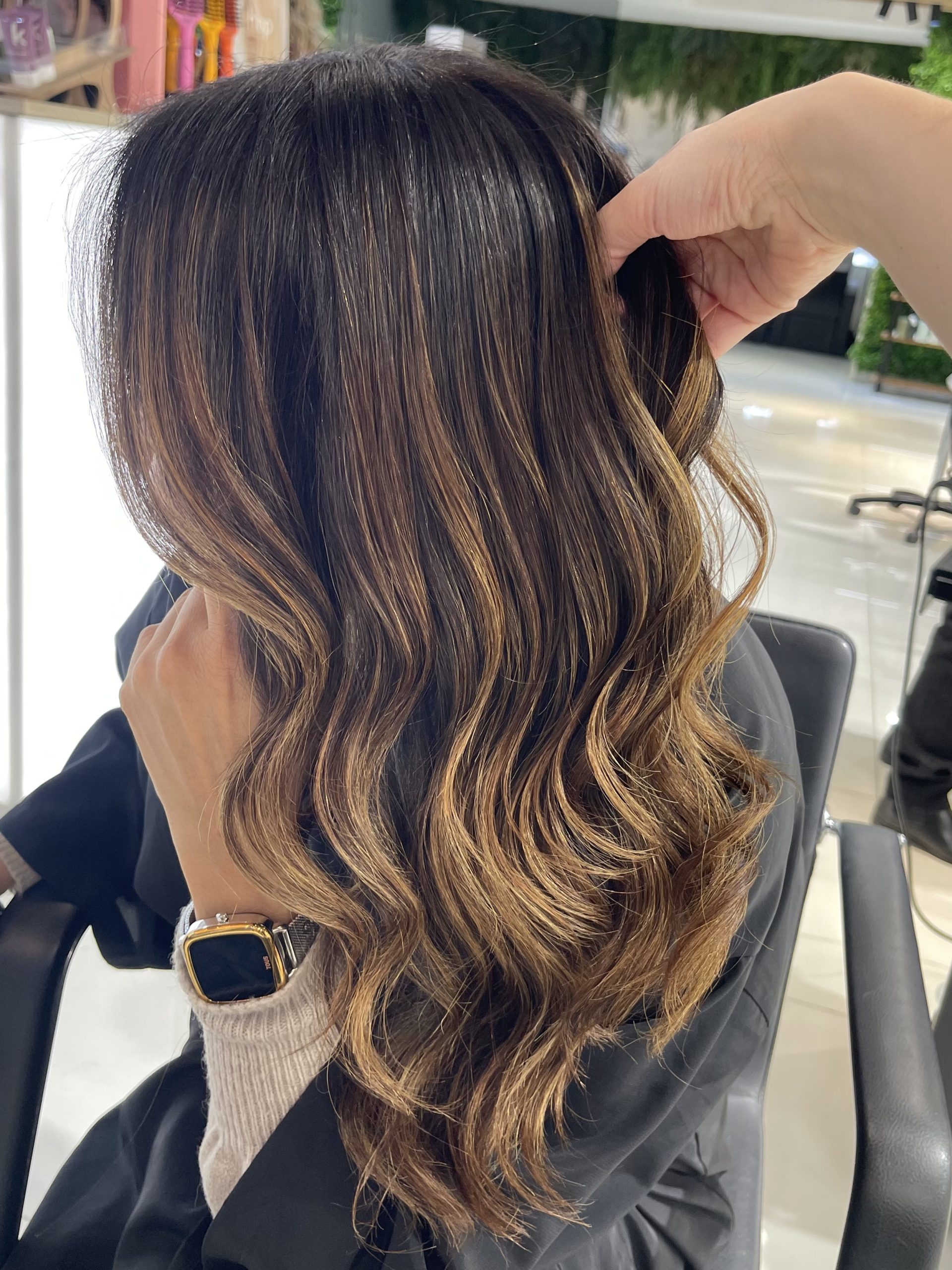 Morena iluminada con reflejos dorados — Identity Peluqueros Valencia
